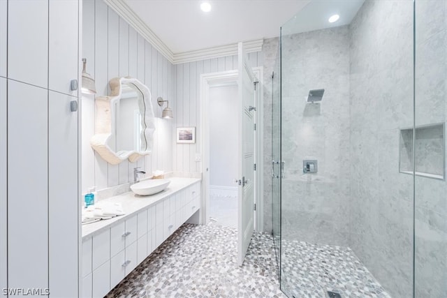 bathroom featuring tile flooring, vanity with extensive cabinet space, an enclosed shower, and ornamental molding