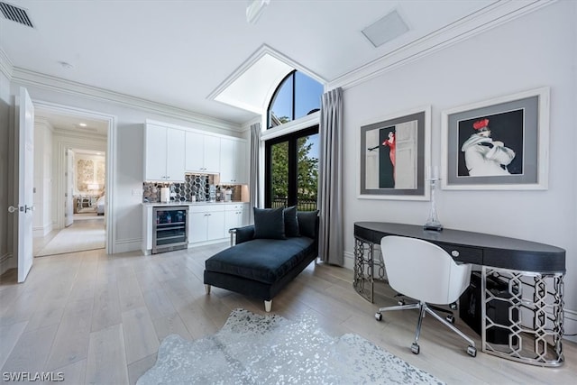 office with ornamental molding, beverage cooler, french doors, and light wood-type flooring