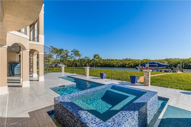 view of swimming pool featuring an in ground hot tub, a patio, and a water view