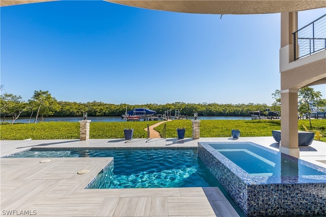 view of pool with a lawn, an in ground hot tub, and a water view