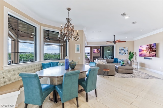 dining area featuring crown molding, light tile patterned floors, and ceiling fan with notable chandelier