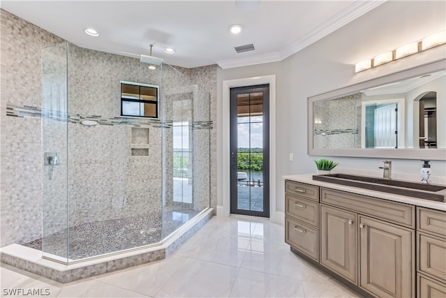 bathroom with a tile shower, vanity, and crown molding