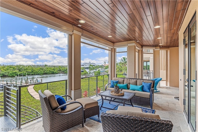 sunroom / solarium featuring a water view and wood ceiling