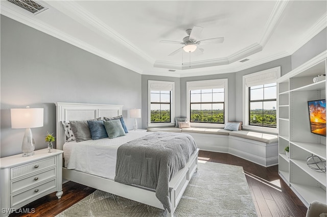 bedroom with dark hardwood / wood-style floors, a raised ceiling, ceiling fan, and ornamental molding