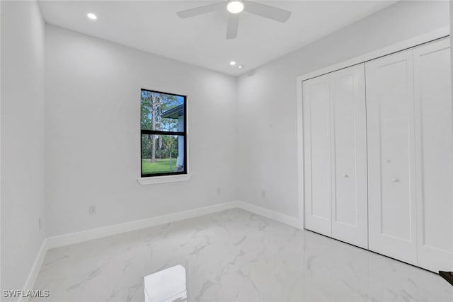 unfurnished bedroom with ceiling fan and a closet