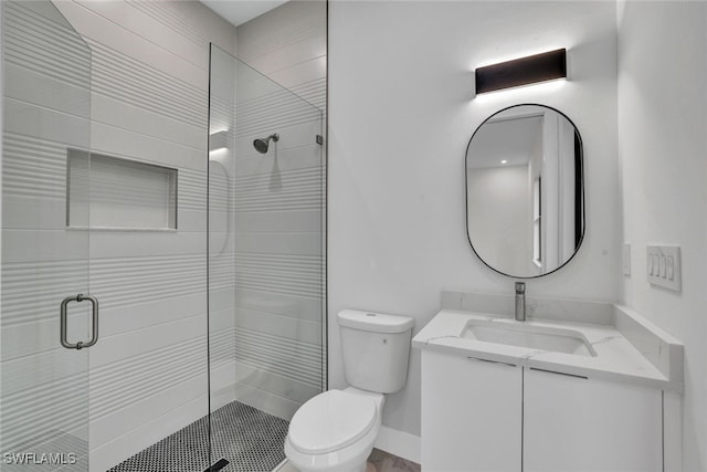 bathroom with a shower with door, vanity, and toilet