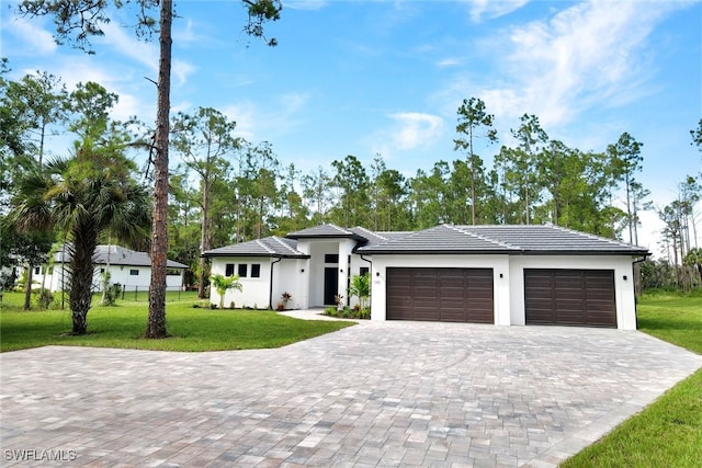 view of front of house with a front yard and a garage