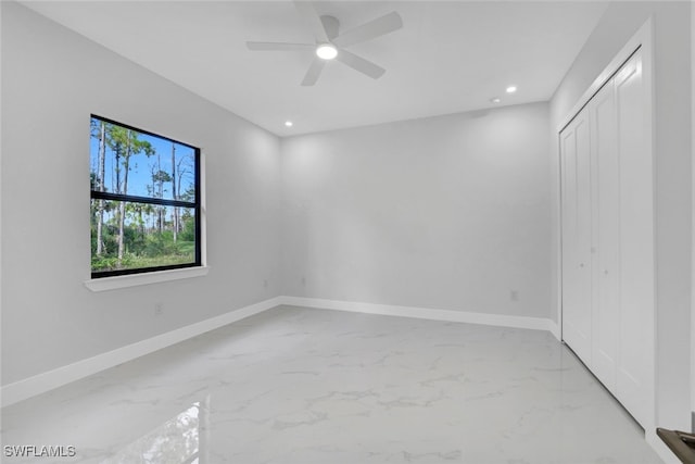 unfurnished bedroom with ceiling fan and a closet