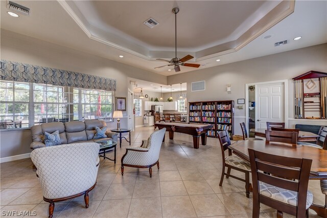 tiled living room featuring a tray ceiling, ceiling fan, and billiards