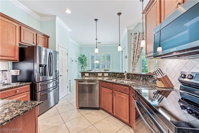 kitchen featuring appliances with stainless steel finishes, decorative light fixtures, ornamental molding, and tasteful backsplash