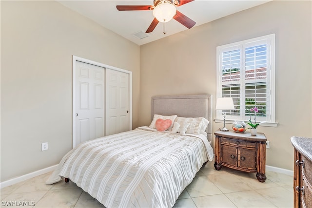 bedroom with ceiling fan, a closet, and light tile patterned floors