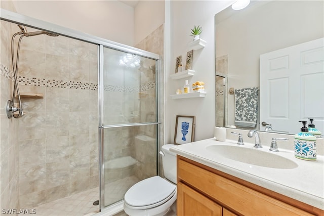 bathroom featuring vanity, toilet, and a shower with door