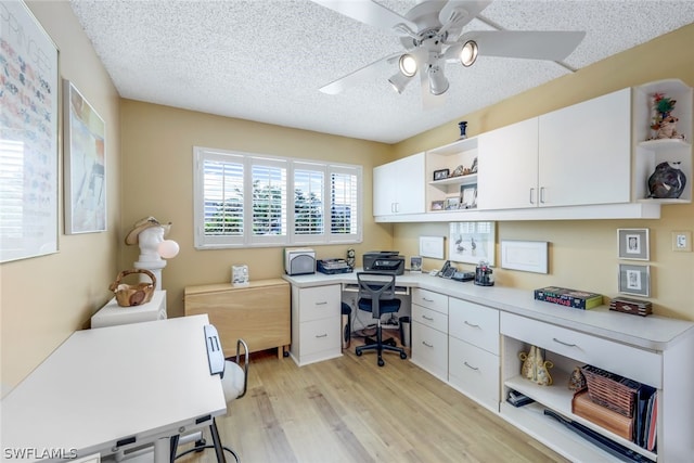 office area with ceiling fan, a textured ceiling, and light hardwood / wood-style flooring