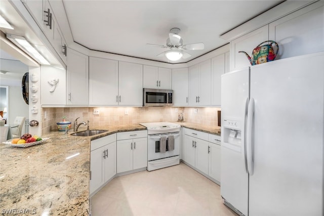 kitchen featuring sink, white appliances, backsplash, light stone countertops, and white cabinets