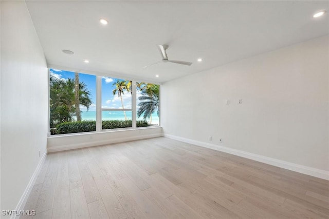 empty room with ceiling fan and light wood-type flooring