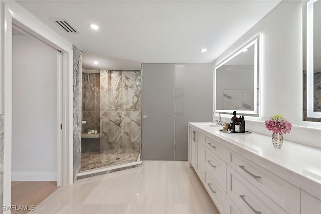 bathroom with vanity and tiled shower