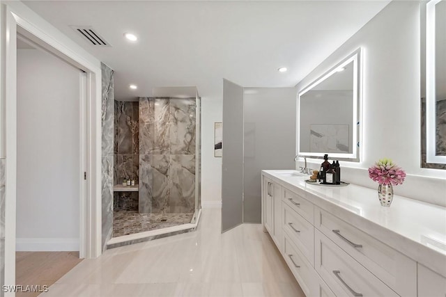 bathroom featuring a tile shower and vanity