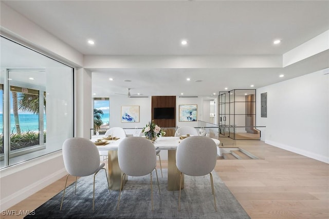 dining room featuring ceiling fan, light hardwood / wood-style floors, and electric panel