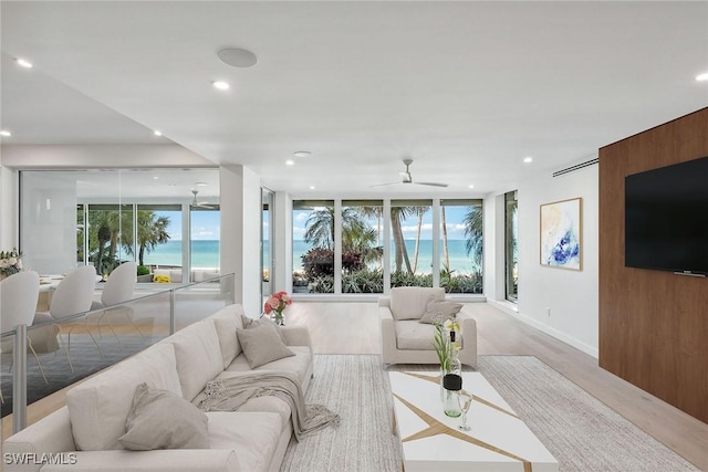 living room featuring floor to ceiling windows, a wealth of natural light, ceiling fan, and wood-type flooring