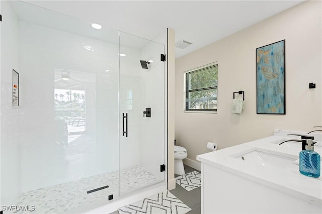 bathroom featuring vanity, an enclosed shower, and toilet