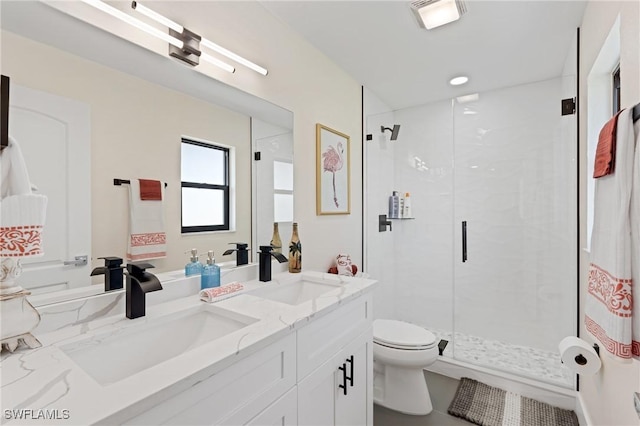 bathroom featuring vanity, toilet, and a shower with door