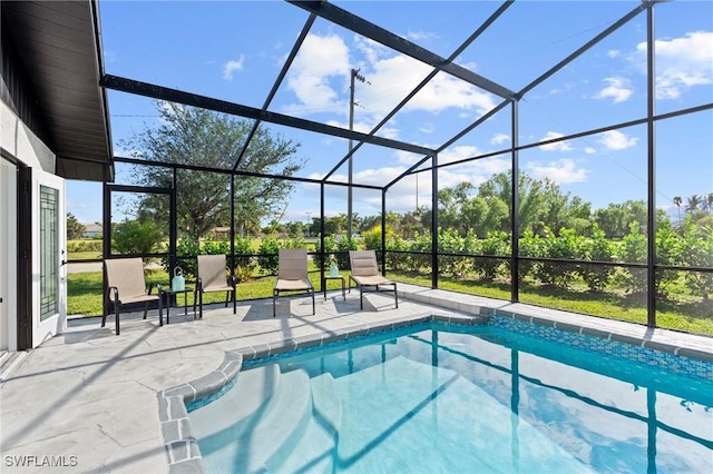 view of swimming pool featuring a patio and glass enclosure