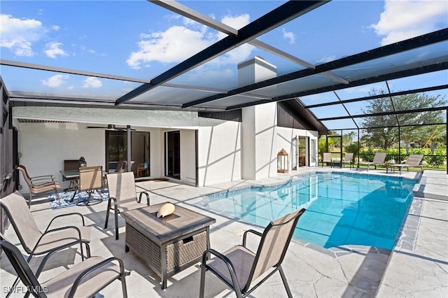 view of swimming pool with a patio, a lanai, and ceiling fan