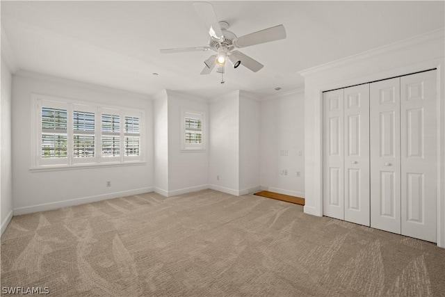 unfurnished bedroom with ceiling fan, crown molding, light carpet, and a closet