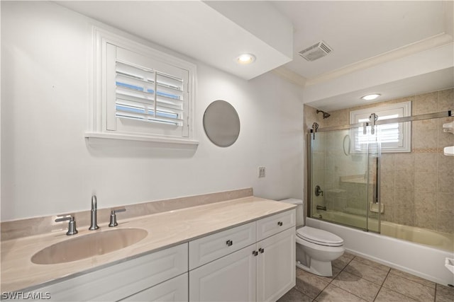 full bathroom featuring vanity, tile patterned floors, combined bath / shower with glass door, toilet, and ornamental molding