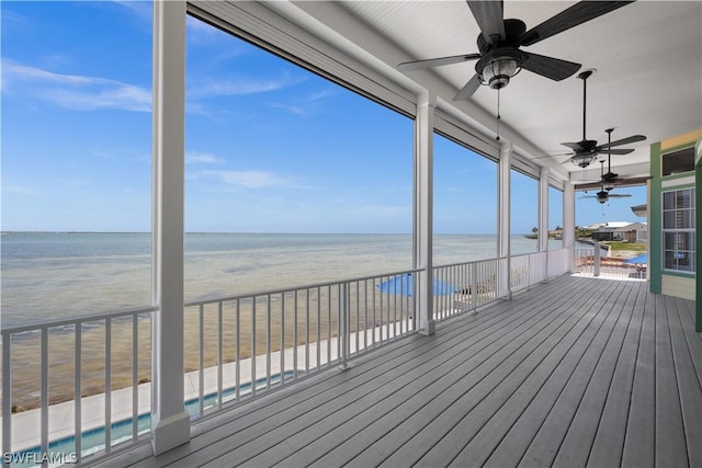 wooden deck featuring a beach view, a water view, and ceiling fan