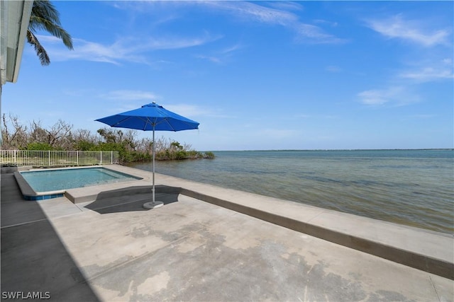 view of swimming pool with a patio area and a water view