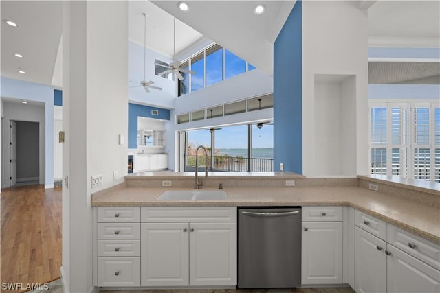 kitchen featuring ceiling fan, dishwasher, sink, a high ceiling, and white cabinets