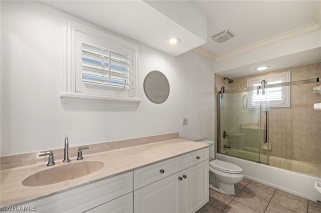 full bathroom with vanity, tile patterned floors, combined bath / shower with glass door, crown molding, and toilet