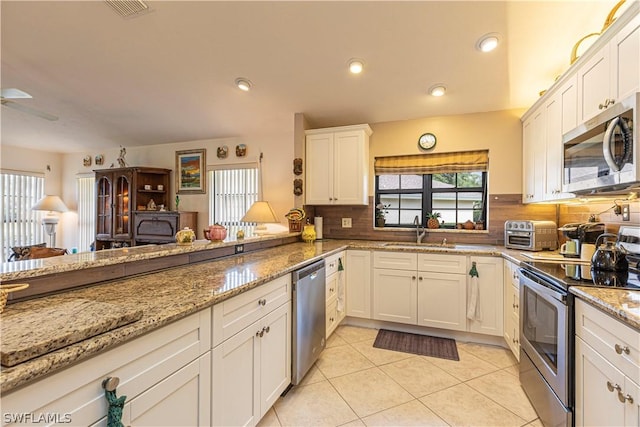 kitchen featuring stainless steel appliances, white cabinets, sink, and kitchen peninsula