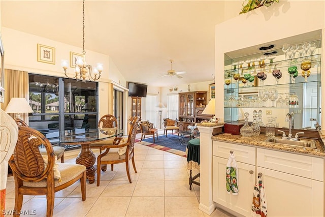 tiled dining room with ceiling fan with notable chandelier, sink, and plenty of natural light