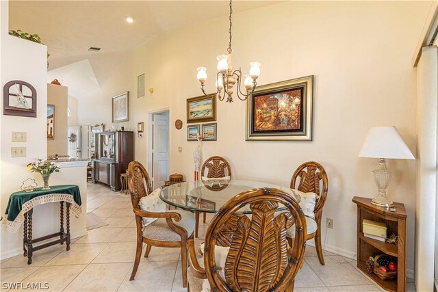 tiled dining space featuring lofted ceiling and a chandelier