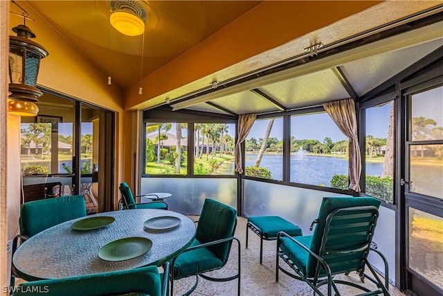 sunroom / solarium featuring vaulted ceiling and a water view