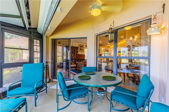 sunroom with ceiling fan and vaulted ceiling