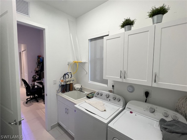 clothes washing area featuring cabinets, light tile floors, washer and clothes dryer, sink, and hookup for an electric dryer