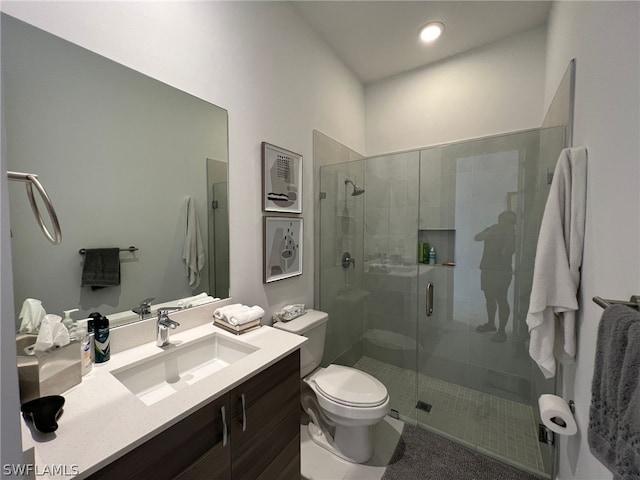 bathroom with vanity, toilet, and a shower with door