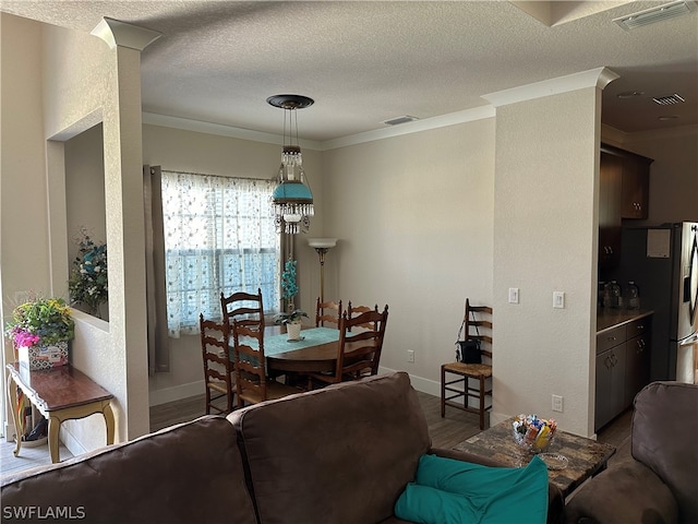 living room with a textured ceiling, dark hardwood / wood-style flooring, and crown molding