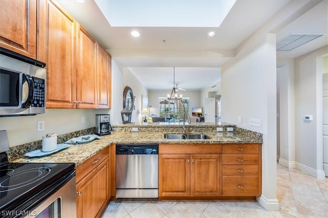 kitchen with appliances with stainless steel finishes, sink, light stone countertops, and light tile floors