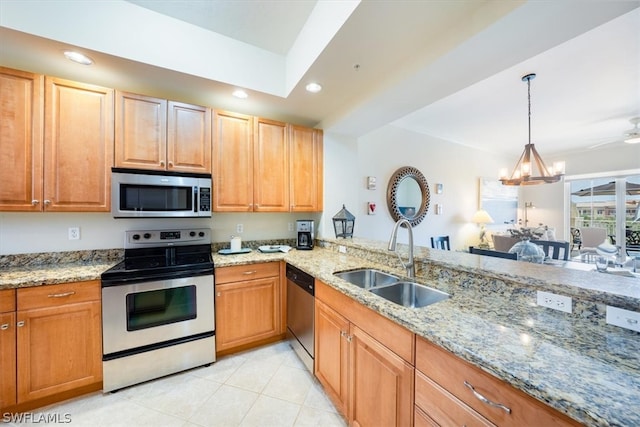 kitchen featuring appliances with stainless steel finishes, light stone counters, decorative light fixtures, sink, and light tile floors