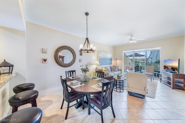 tiled dining area featuring ceiling fan with notable chandelier