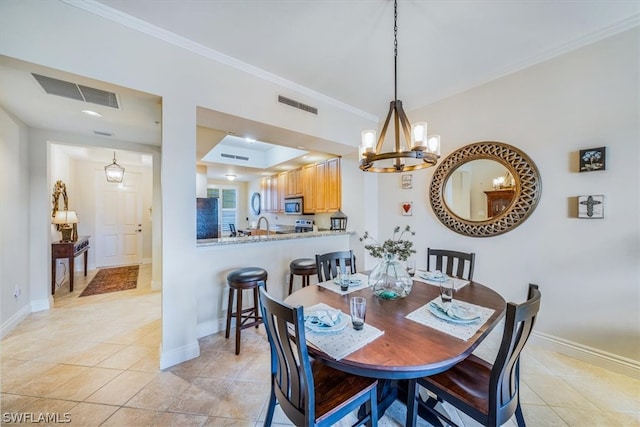 dining space with sink, ornamental molding, a chandelier, and light tile floors