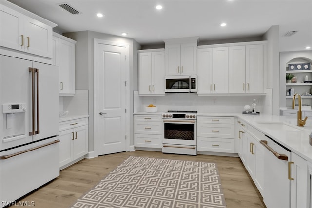 kitchen featuring white cabinetry, light hardwood / wood-style flooring, sink, and high end appliances