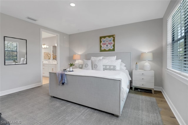 bedroom featuring ensuite bathroom and wood-type flooring