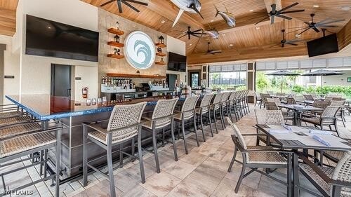 kitchen with a breakfast bar area, white cabinets, high vaulted ceiling, and wooden ceiling