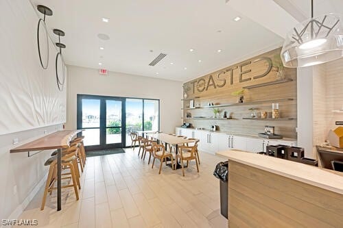 kitchen with french doors, a notable chandelier, decorative light fixtures, and light hardwood / wood-style floors