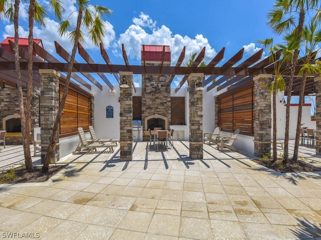 view of terrace with a pergola and an outdoor stone fireplace